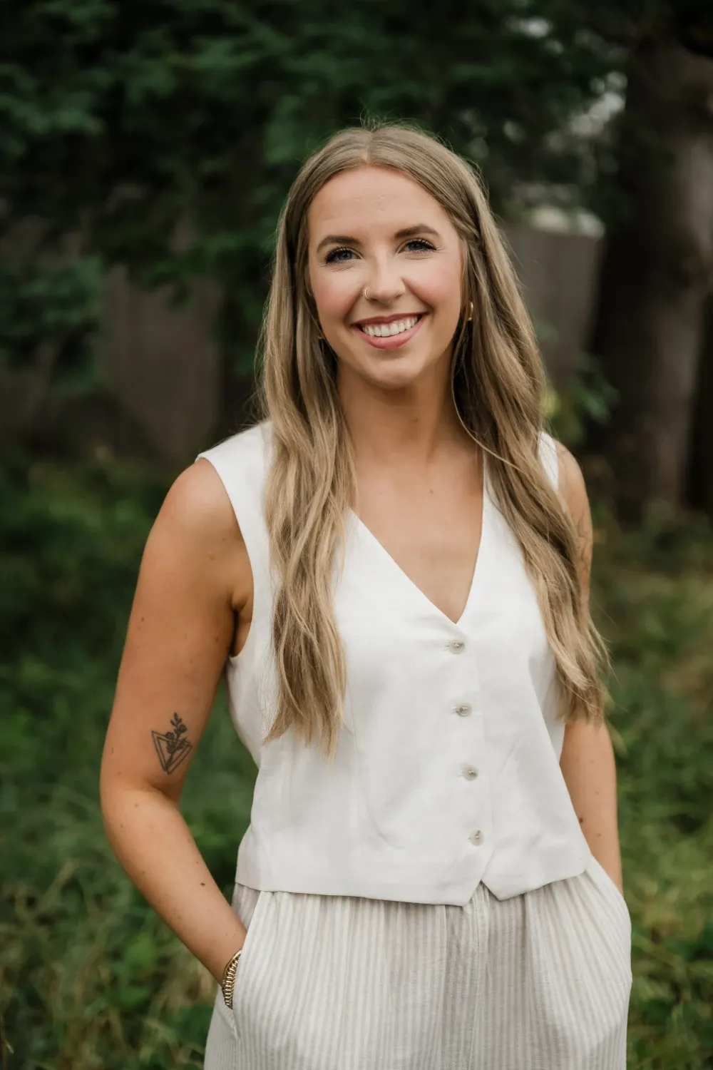 A picture of Andrea. She's got blonde hair and a taupe vest on.